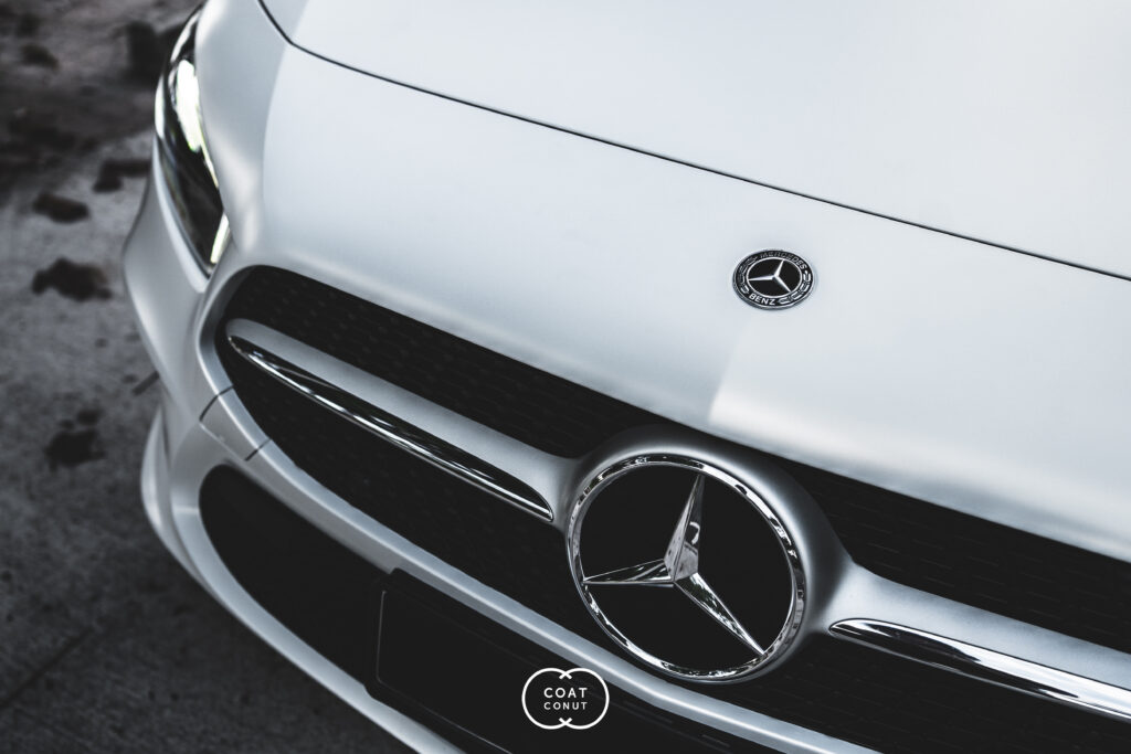 White Mercedes-Benz front grille and badge, glossy paint in the studio