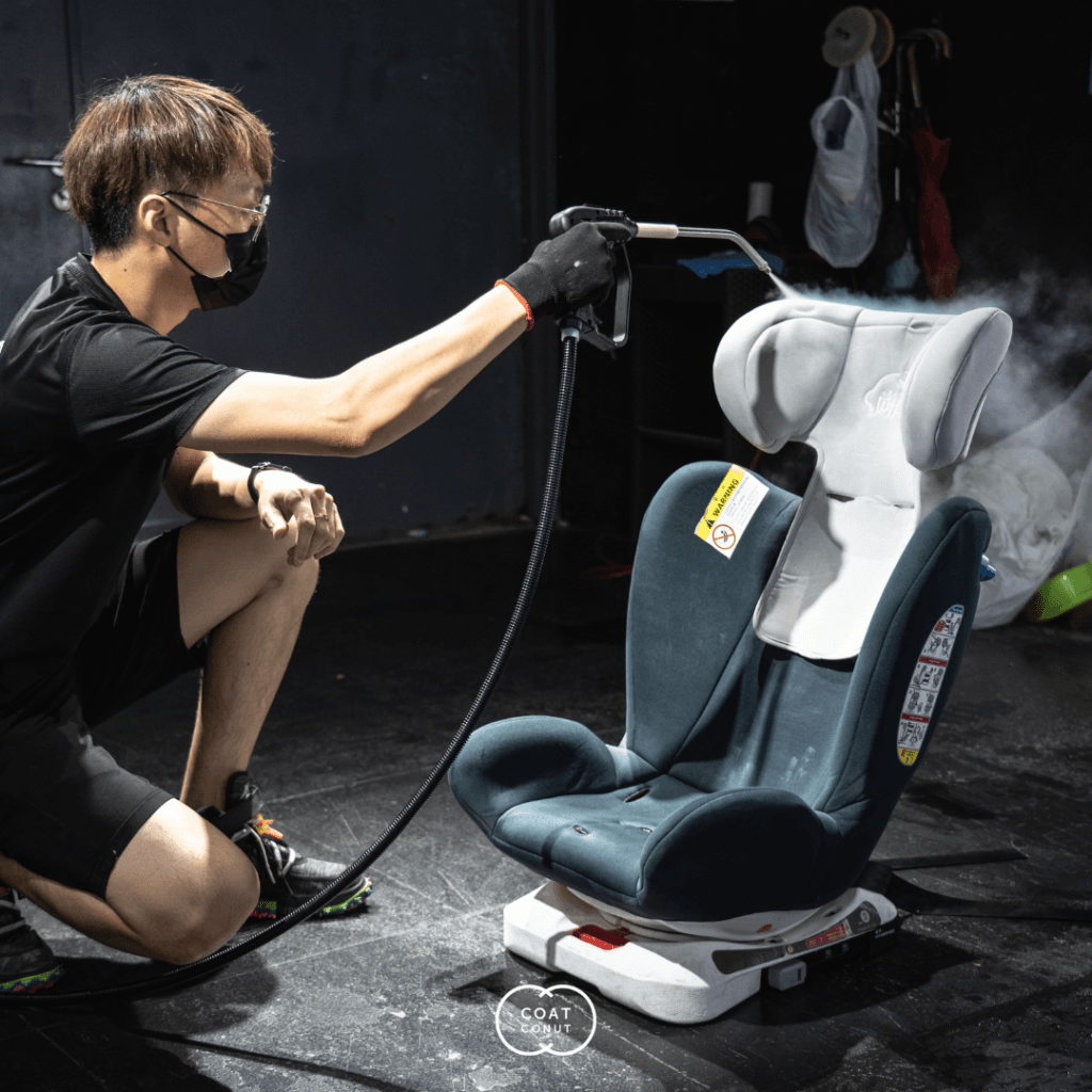 Child car seat being deep cleaned with a steam extraction tool