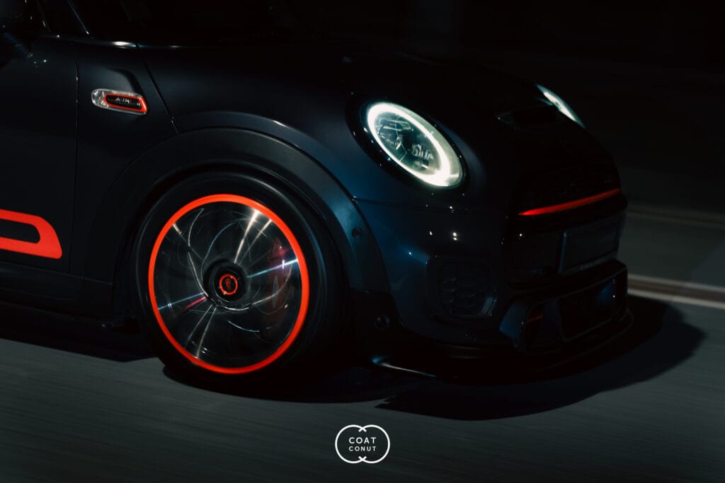 MINI JCW with red Luminor illuminated rims glowing at night
